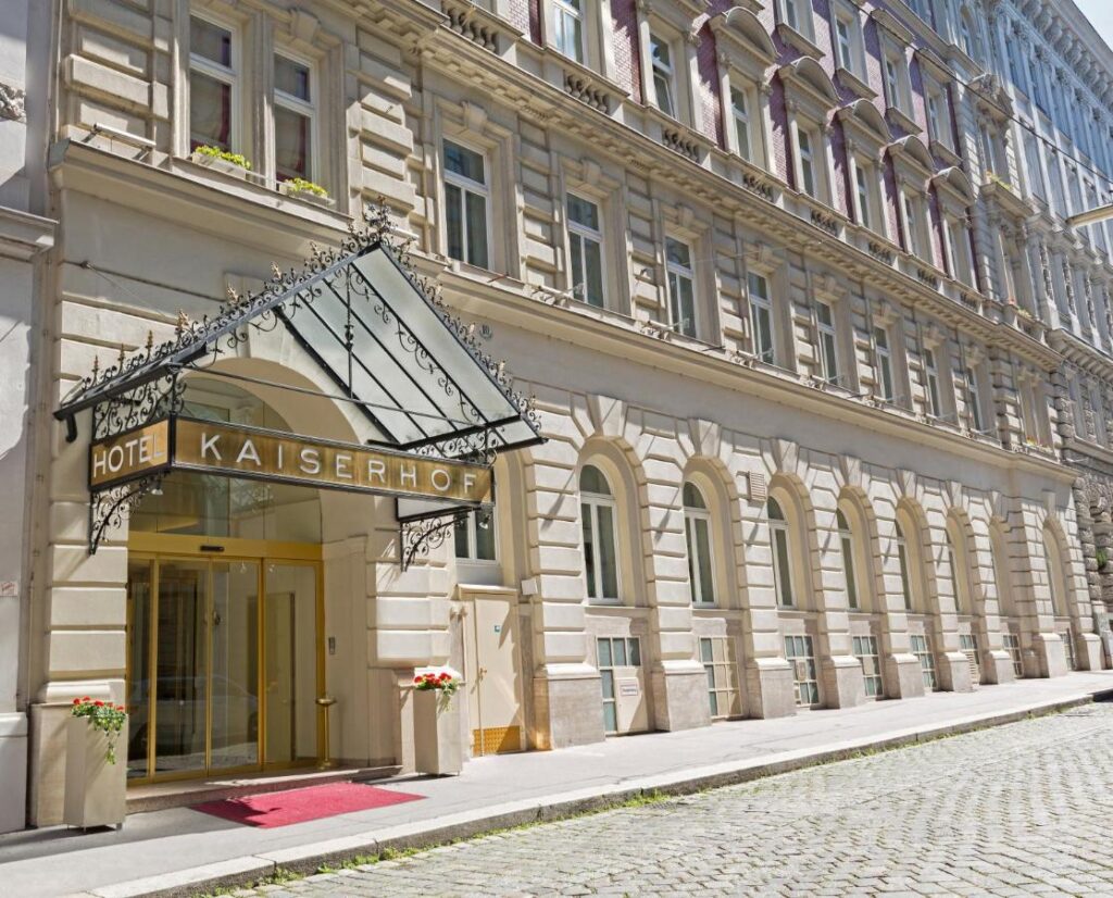 Entrance to the Hotel Kaiserhof with glass roof and golden letters on the façade.
