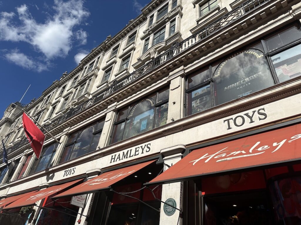 Facade of Hamleys toy store with red awnings and windows in London.