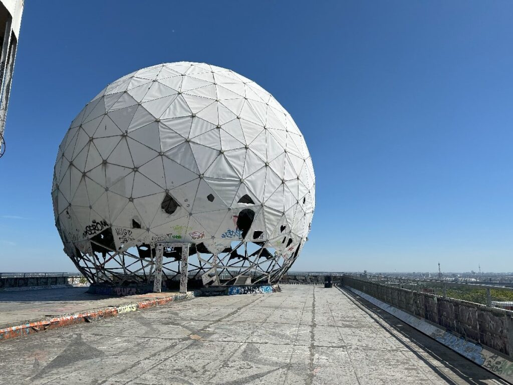The large white radar dome at Teufelsberg, a former Cold War listening station in Berlin, covered in graffiti.