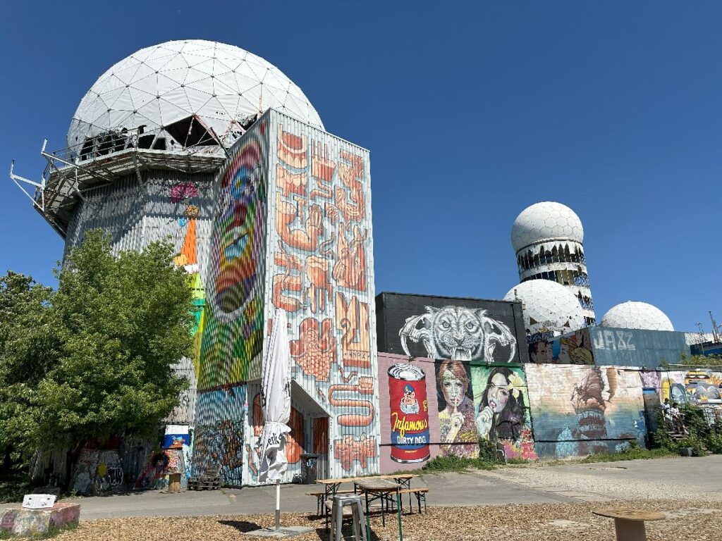 Colorful murals cover Berlin’s Teufelsberg listening station, where large radar domes rise above the former Cold War site.