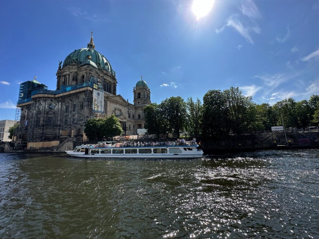 A sightseeing boat passes Berlin Cathedral on Museum Island, a historic landmark to see during a two-day Berlin itinerary.