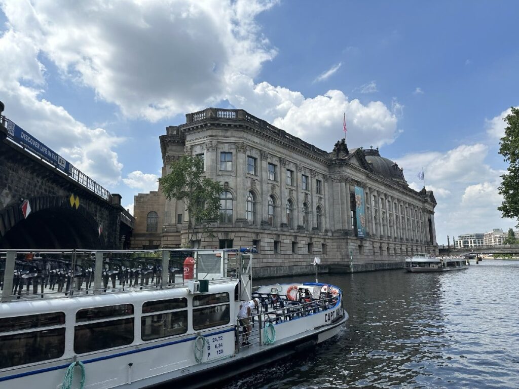 A passenger boat cruises along the Spree beside the Bode Museum on Museum Island during a family-friendly Berlin outing.